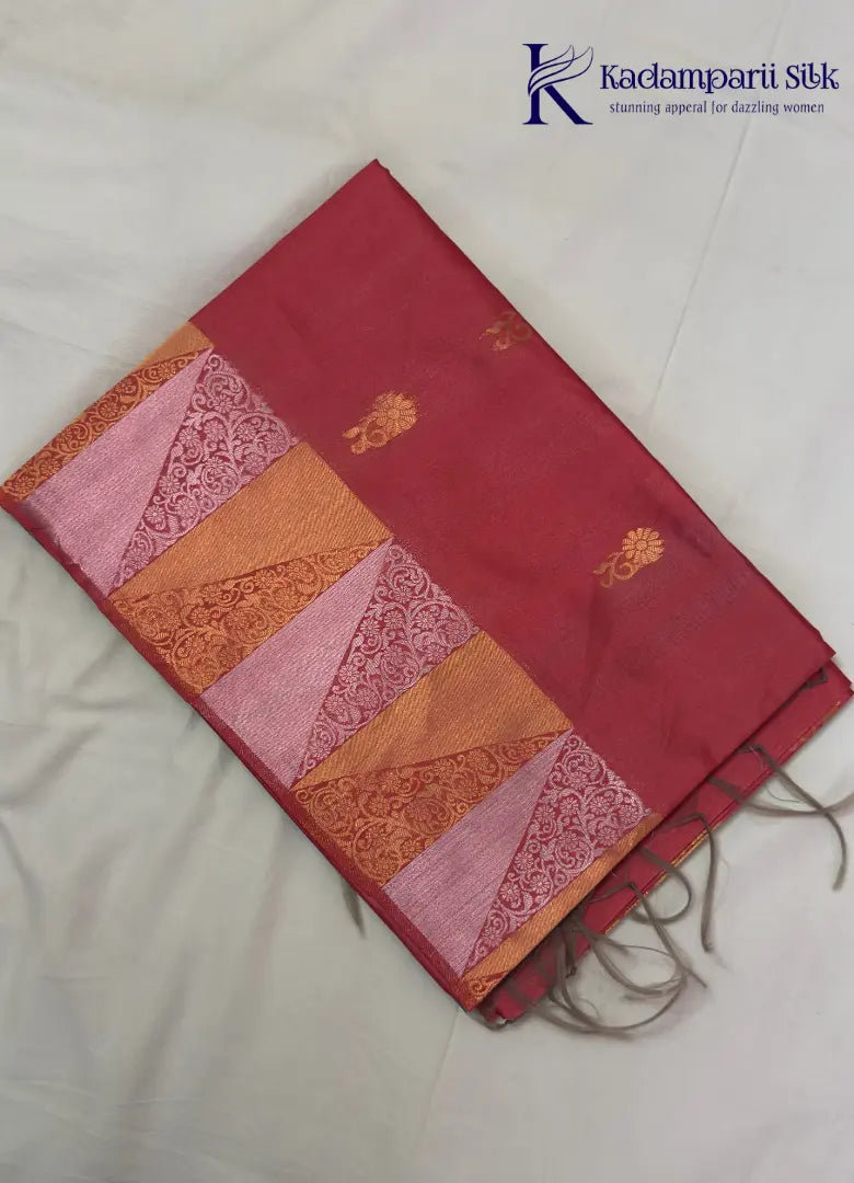 Pink semi raw silk saree with zari work and copper patterned border, folded on a light background.