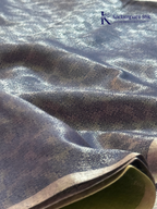 Charcoal grey semi Tussar jacquard saree with intricate woven self-patterns, subtle silver zari border, soft textured finish, elegant tassels, and lightweight graceful drape by Kadamparii Silk.