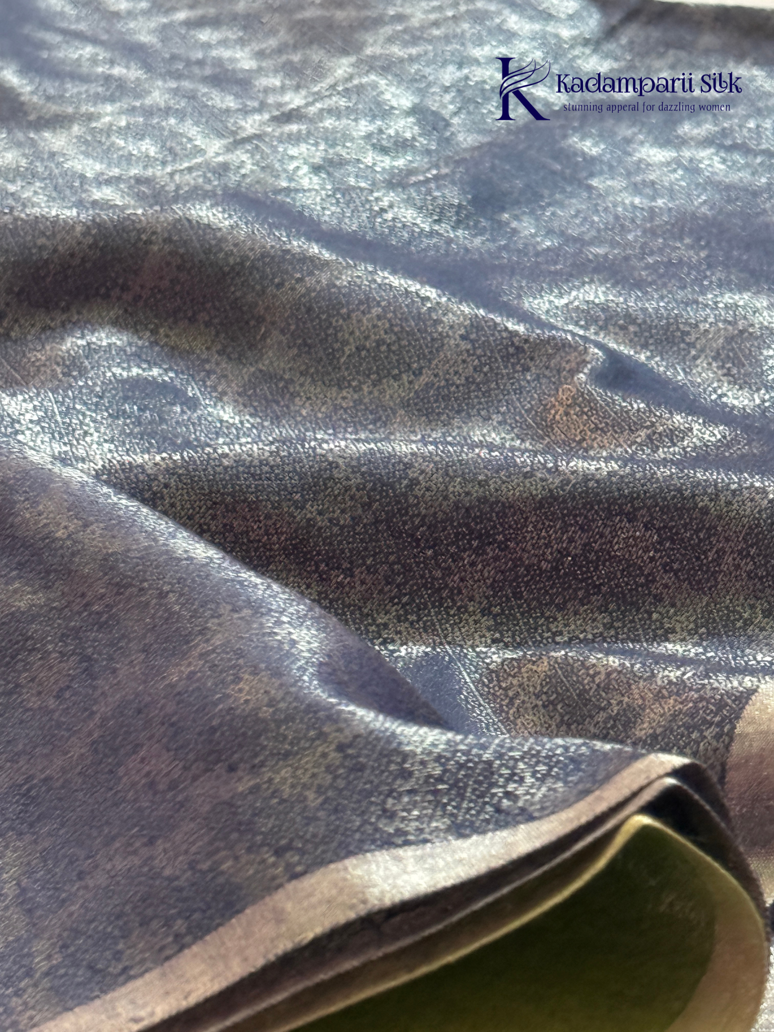 Charcoal grey semi Tussar jacquard saree with intricate woven self-patterns, subtle silver zari border, soft textured finish, elegant tassels, and lightweight graceful drape by Kadamparii Silk.