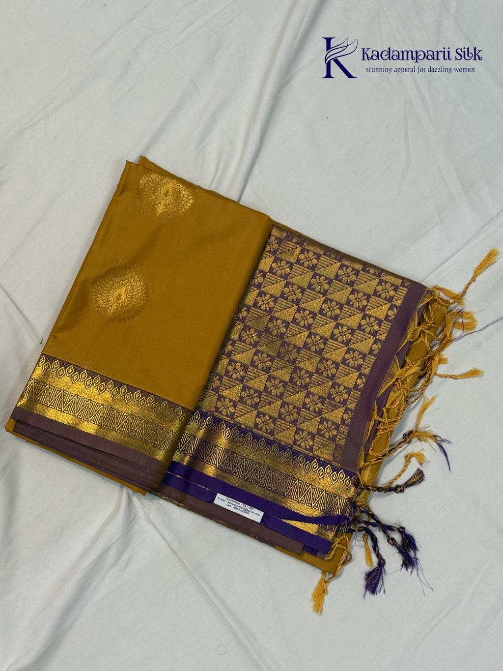 Kadamparii Silk mustard yellow semi soft silk saree with gold zari motifs, rich purple checkered zari pallu, ornate woven border, royal blue accents, and tassel detailing.