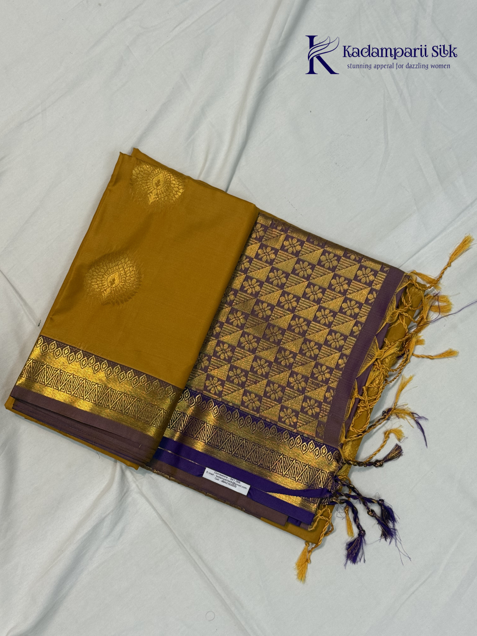 Kadamparii Silk mustard yellow semi soft silk saree with gold zari motifs, rich purple checkered zari pallu, ornate woven border, royal blue accents, and tassel detailing.