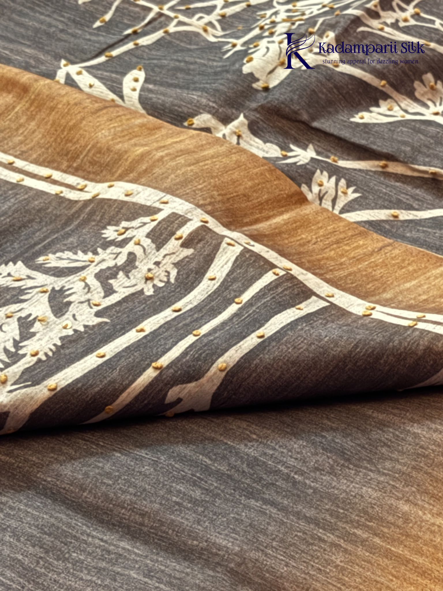 Grey Chenderi silk cotton saree with elegant floral vine design, intricate French knot work, copper-toned border and pallu, soft lightweight fabric, tassel detailing, and graceful ethnic styling by Kadamparii Silk.