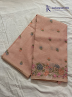 Blush pink super net saree with delicate multicolor floral embroidery, soft textured weave, lightweight sheer fabric, elegant feminine detailing, and graceful modern drape by Kadamparii Silk.