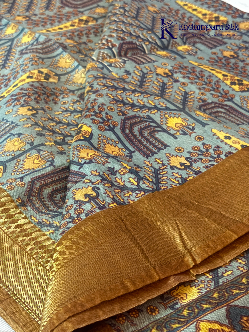Kadamparii Silk grey semi tussar printed saree with traditional floral and heritage motifs, golden woven border, soft textured fabric, elegant tassels, and sophisticated ethnic design.