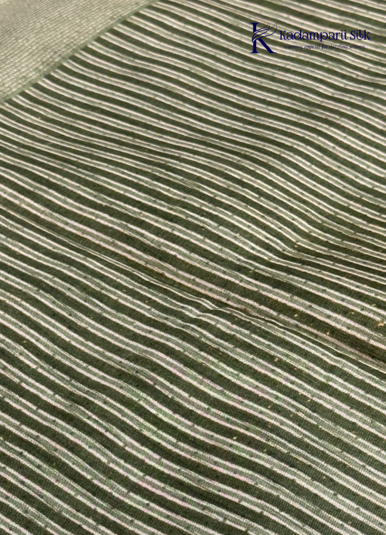 Kadamparii Silk olive green soft tussar silk saree with textured woven body and silver zari border, displayed on a white background.