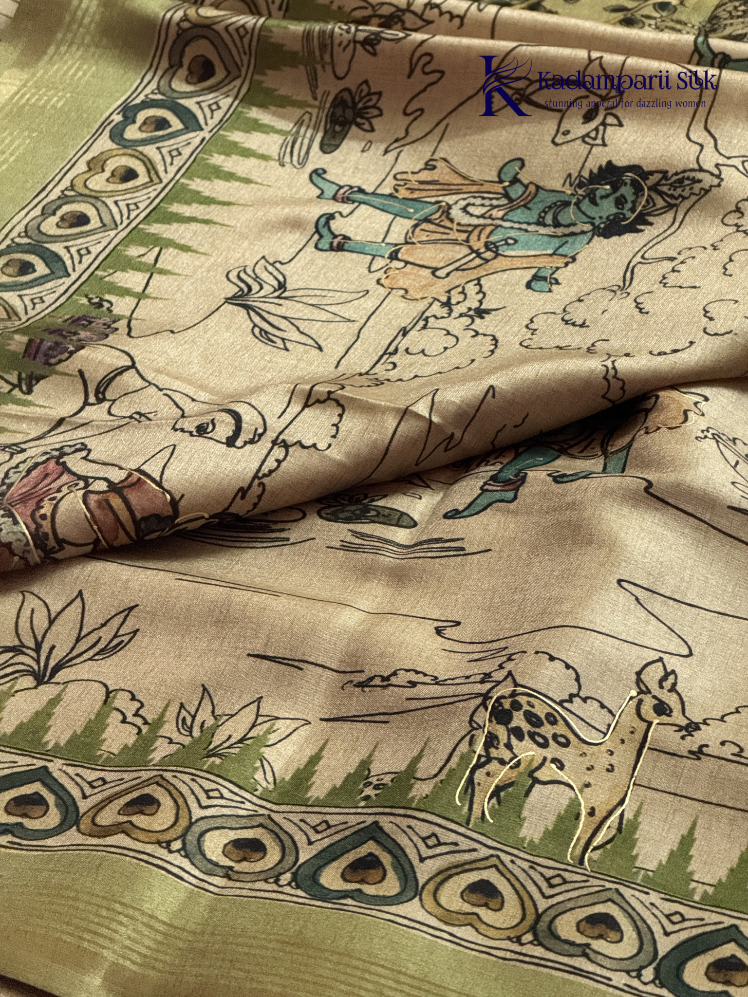Soft Tussar saree with traditional pencil art print featuring mythological village scene motifs, subtle olive green zari border, artistic hand-drawn style detailing, and elegant lightweight drape by Kadamparii Silk.