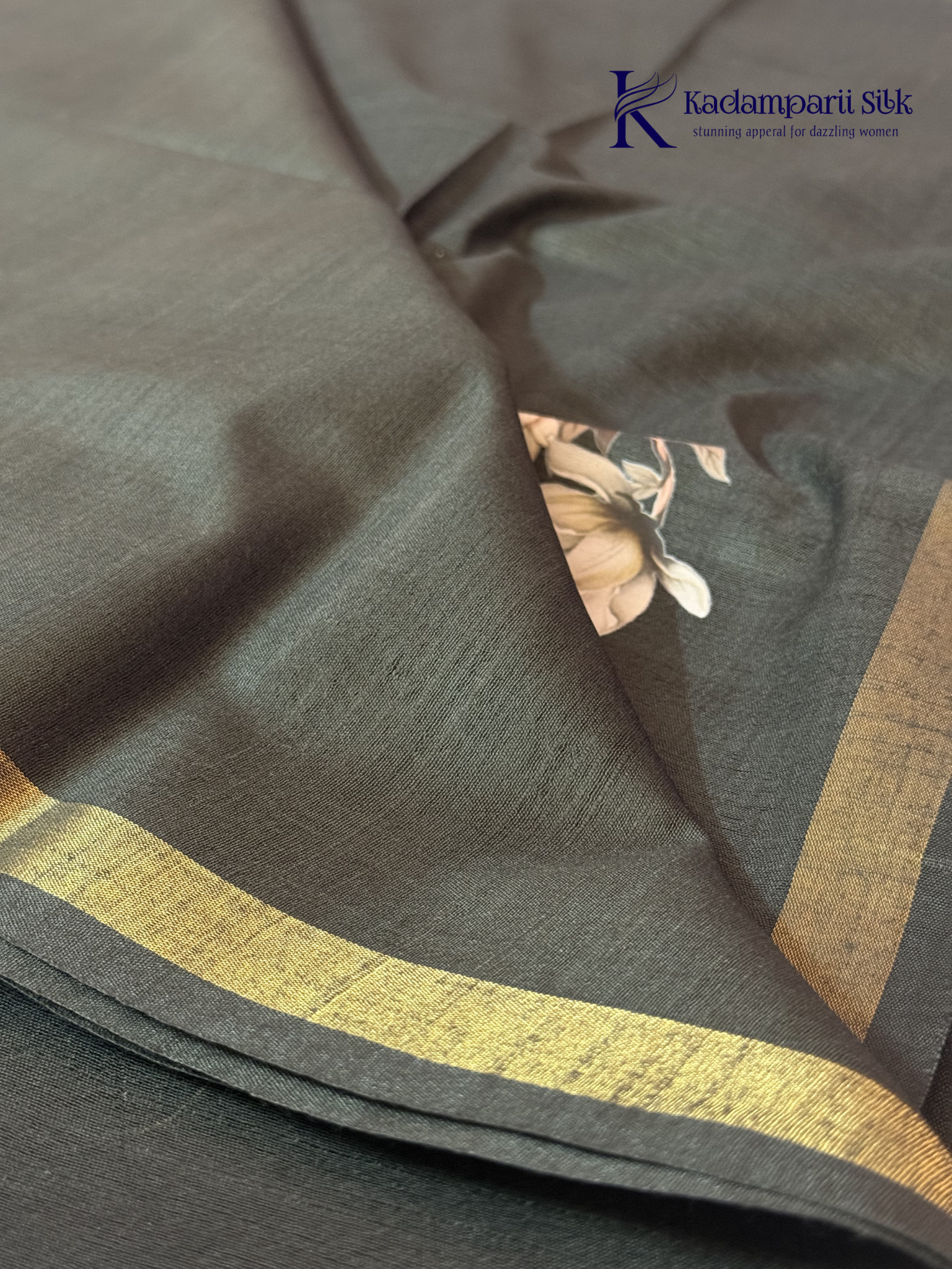 Black semi tussar saree with floral digital print and subtle golden zari border by Kadamparii Silk.