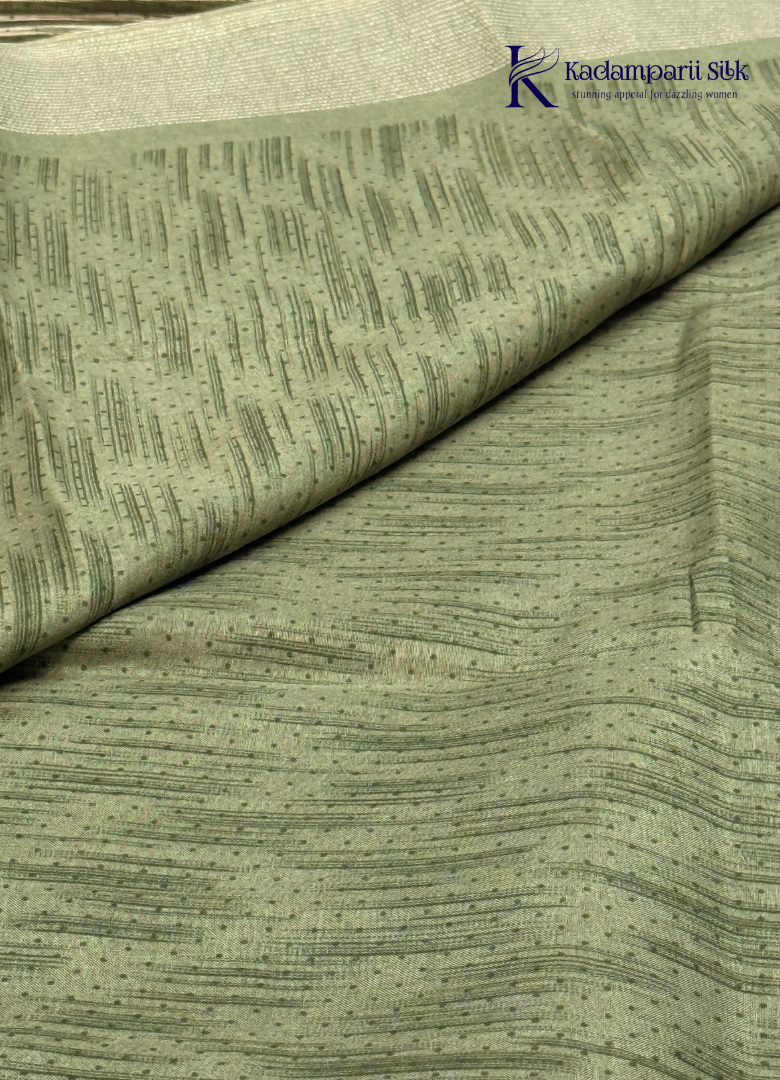 Kadamparii Silk olive green soft tussar silk saree with textured woven body and silver zari border, displayed on a white background.