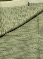 Kadamparii Silk olive green soft tussar silk saree with textured woven body and silver zari border, displayed on a white background.