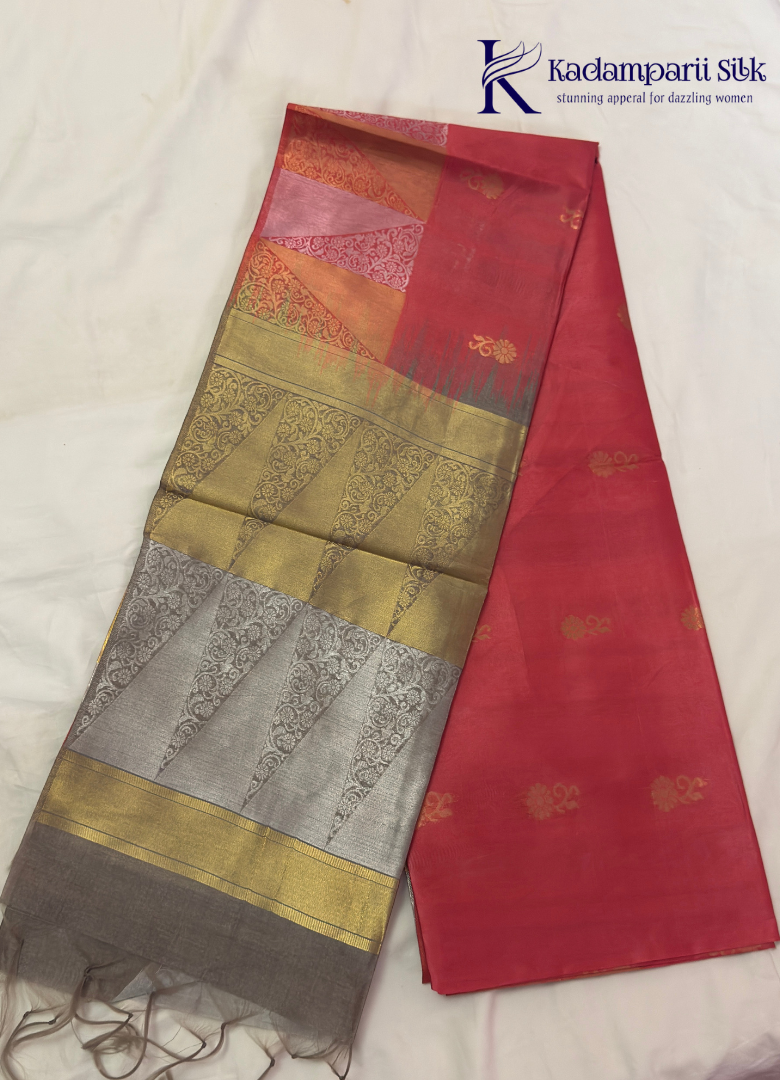 Kadamparii Silk pink semi raw silk saree with zari work and copper patterned border, folded on a light background.