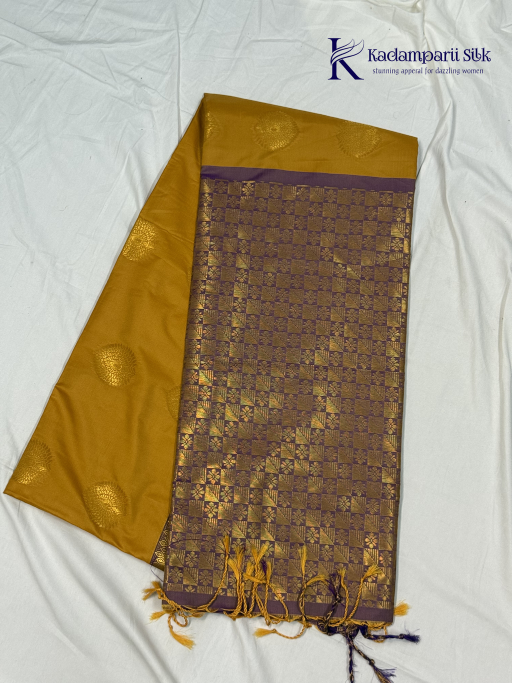Kadamparii Silk mustard yellow semi soft silk saree with gold zari motifs, rich purple checkered zari pallu, ornate woven border, royal blue accents, and tassel detailing.