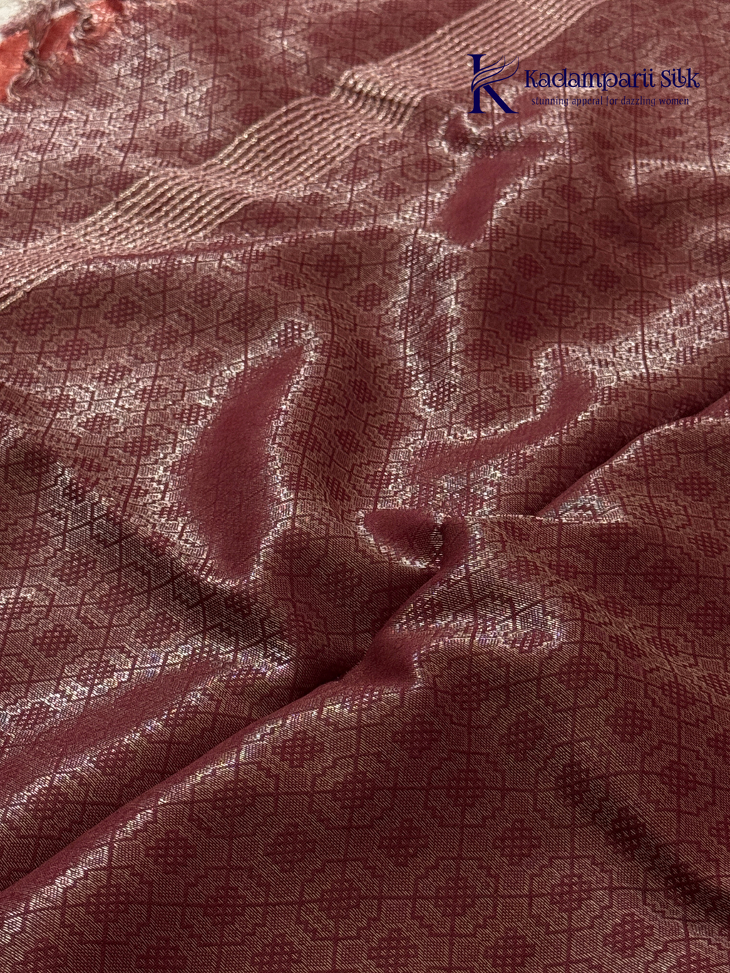 Rose pink semi Tussar jacquard saree with all-over woven geometric patterns, subtle silver zari detailing, soft textured finish, elegant tassels, and lightweight traditional drape by Kadamparii Silk.
