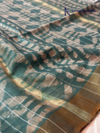 Kadamparii Silk teal semi tussar batik printed saree with abstract geometric patterns, subtle golden woven accents, soft textured fabric, tassel detailing, and elegant traditional design.