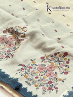Ivory linen tissue saree with delicate handwork floral embroidery, elegant blue tissue pallu and border, soft lightweight texture, tassel detailing, and graceful ethnic styling by Kadamparii Silk.