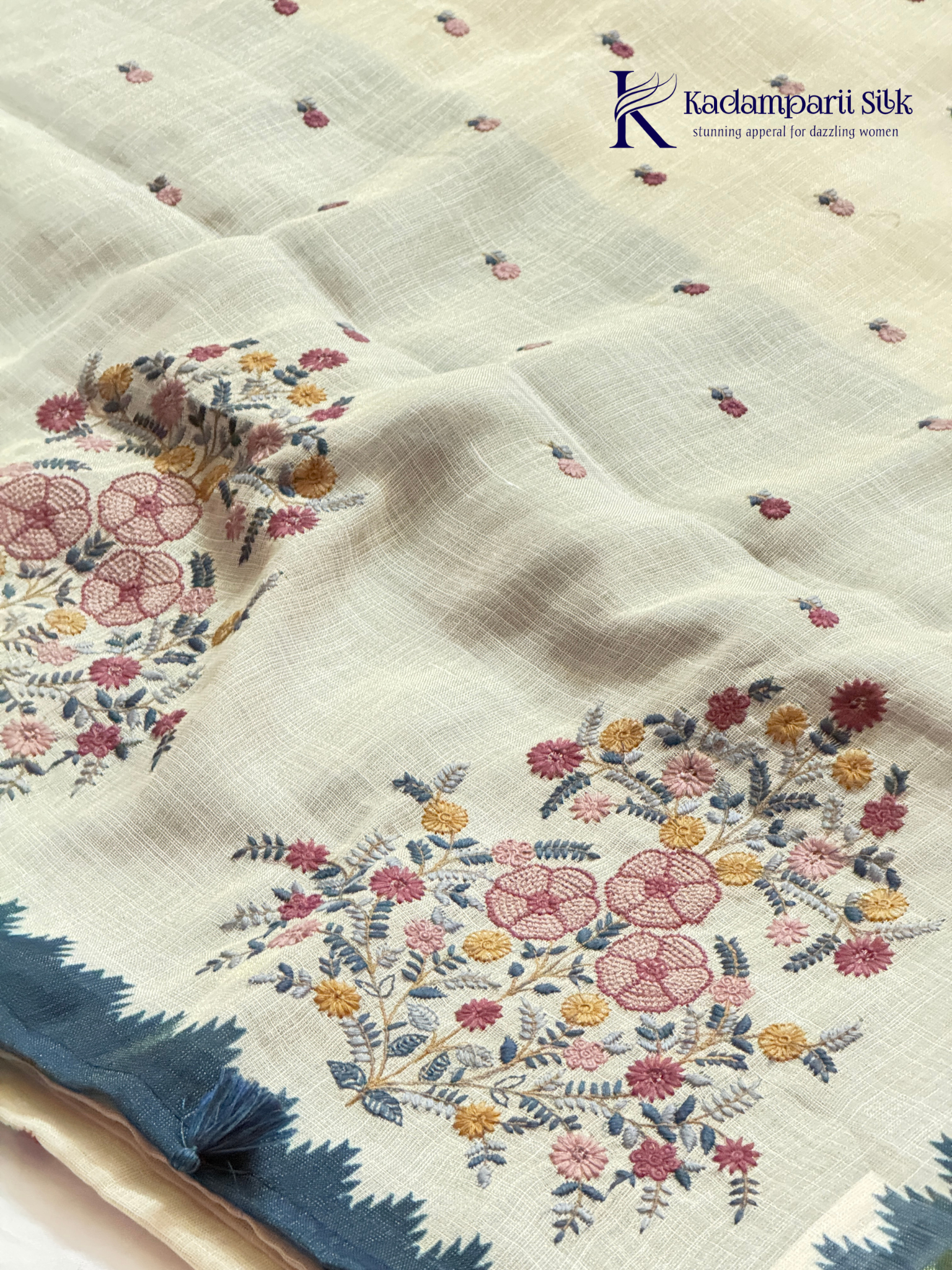 Ivory linen tissue saree with delicate handwork floral embroidery, elegant blue tissue pallu and border, soft lightweight texture, tassel detailing, and graceful ethnic styling by Kadamparii Silk.