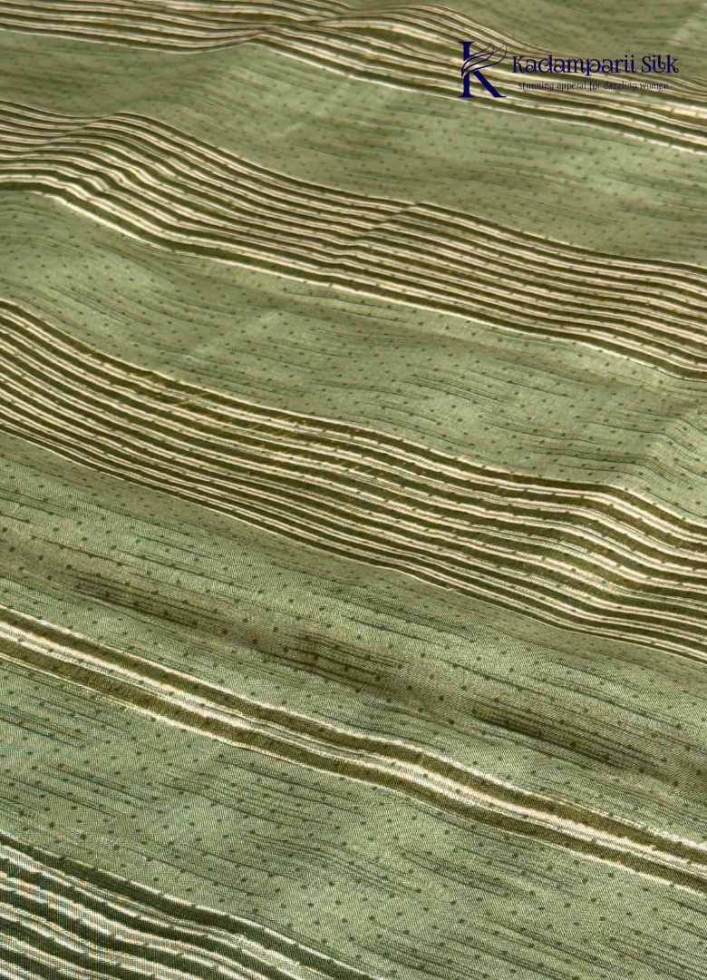 Kadamparii Silk olive green soft tussar silk saree with textured woven body and silver zari border, displayed on a white background.