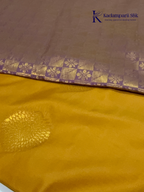 Kadamparii Silk mustard yellow semi soft silk saree with gold zari motifs, rich purple checkered zari pallu, ornate woven border, royal blue accents, and tassel detailing.