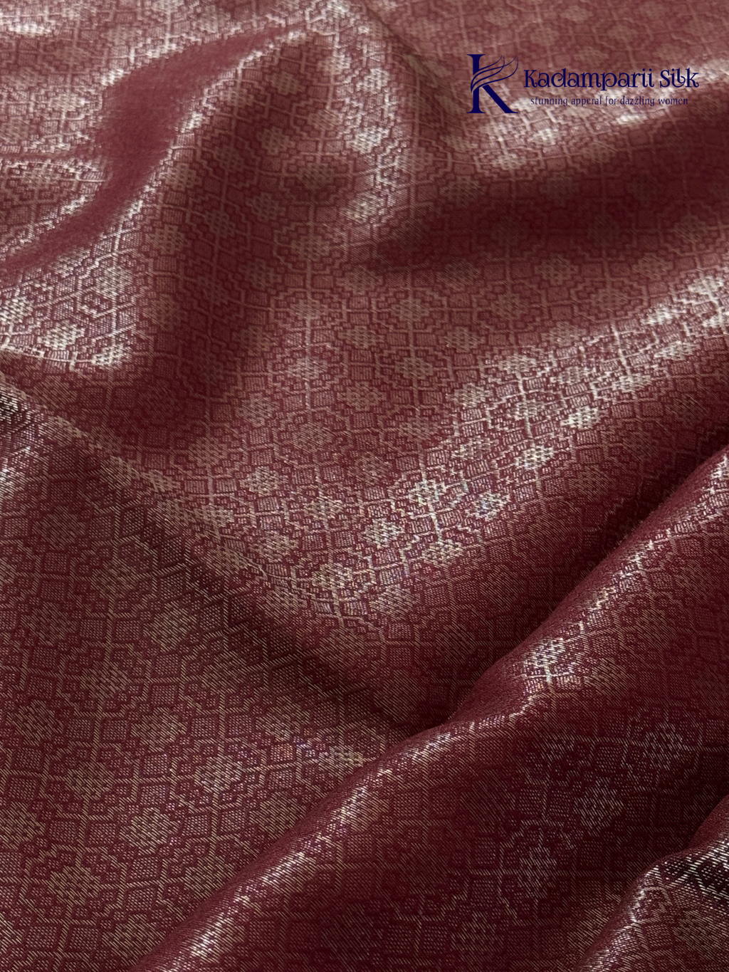 Rose pink semi Tussar jacquard saree with all-over woven geometric patterns, subtle silver zari detailing, soft textured finish, elegant tassels, and lightweight traditional drape by Kadamparii Silk.
