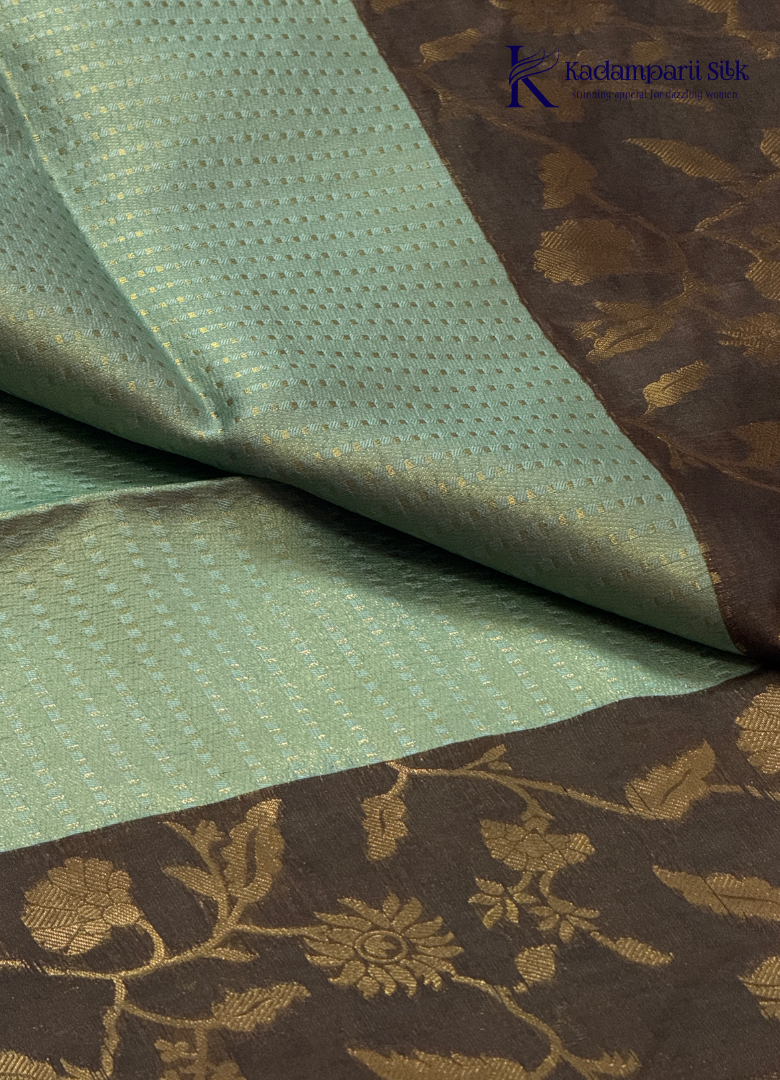 Kadamparii Silk mint green raw silk saree with floral zari border and subtle zari detailing, displayed on a white background.