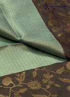 Kadamparii Silk mint green raw silk saree with floral zari border and subtle zari detailing, displayed on a white background.