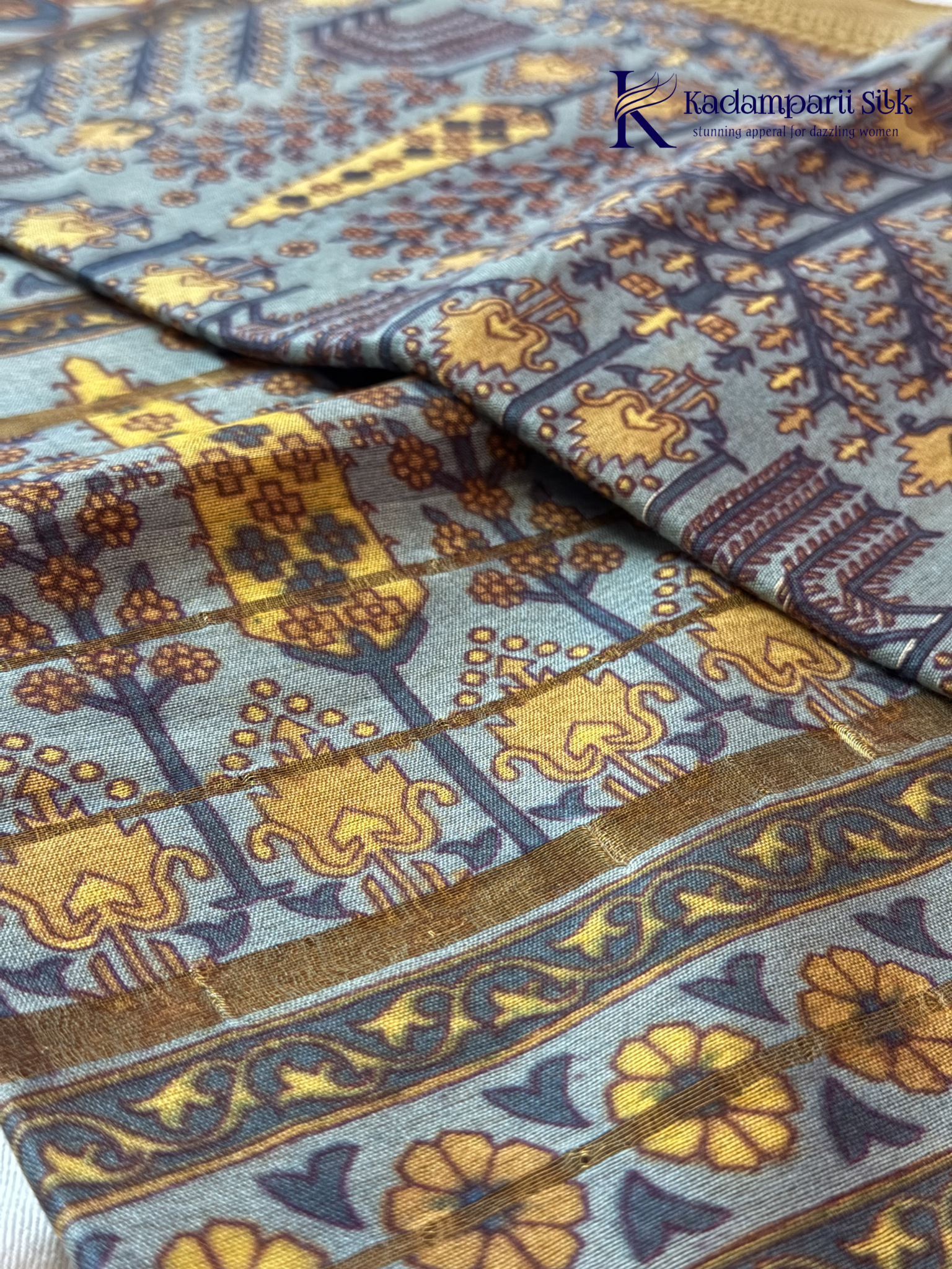 Kadamparii Silk grey semi tussar printed saree with traditional floral and heritage motifs, golden woven border, soft textured fabric, elegant tassels, and sophisticated ethnic design.