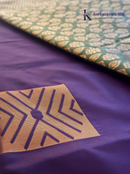 Kadamparii Silk royal purple semi soft silk saree with olive green zari woven pallu, intricate checkered motifs, copper gold zari border, geometric zari designs, and tassel detailing.
