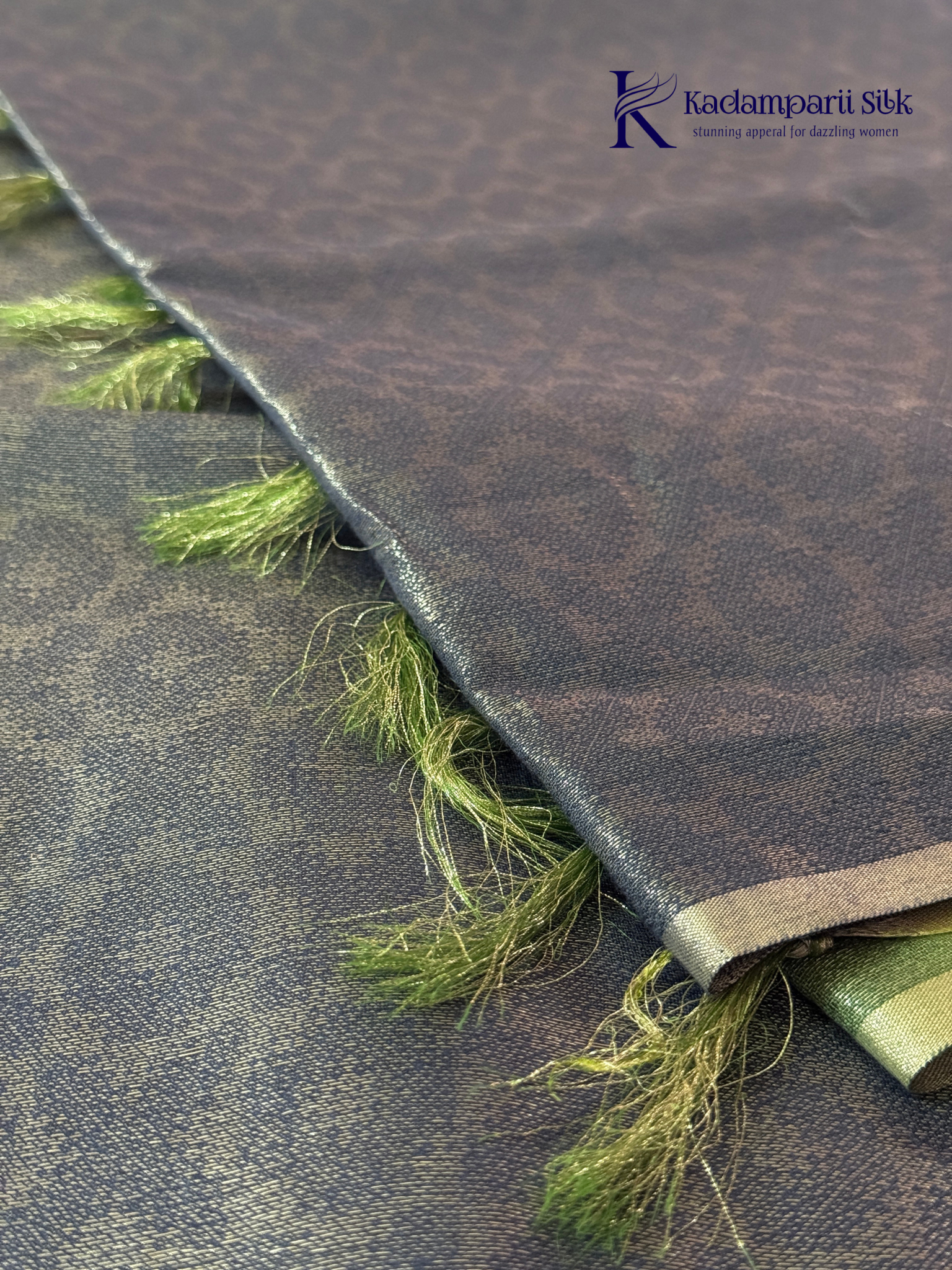 Charcoal grey semi Tussar jacquard saree with intricate woven self-patterns, subtle silver zari border, soft textured finish, elegant tassels, and lightweight graceful drape by Kadamparii Silk.
