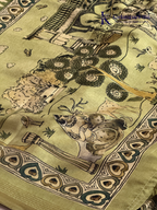 Soft Tussar saree with traditional pencil art print featuring mythological village scene motifs, subtle olive green zari border, artistic hand-drawn style detailing, and elegant lightweight drape by Kadamparii Silk.