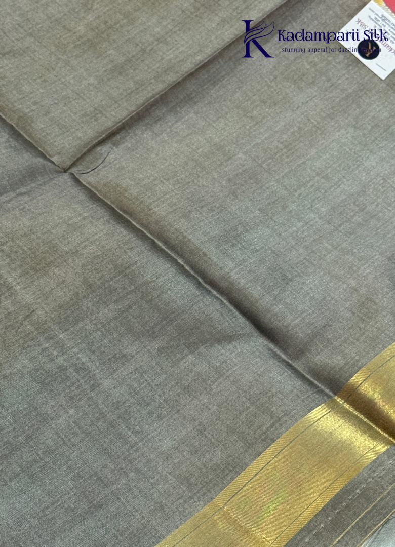Kadamparii Silk pink semi raw silk saree with zari work and copper patterned border, folded on a light background.