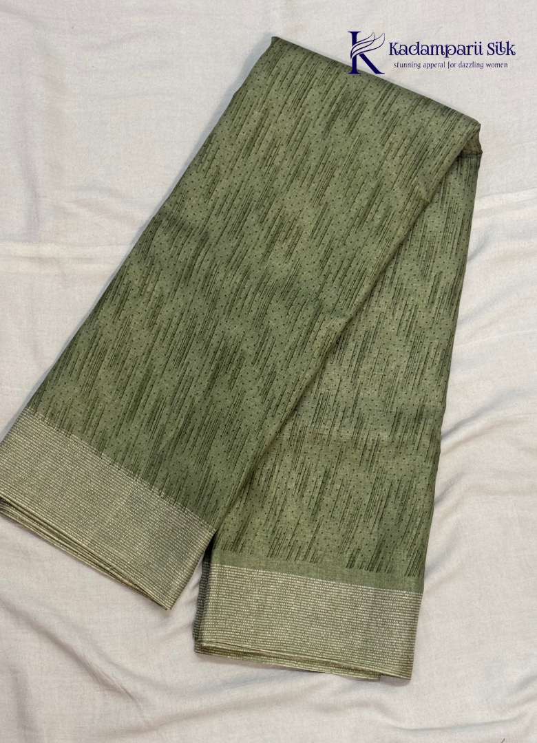 Kadamparii Silk olive green soft tussar silk saree with textured woven body and silver zari border, displayed on a white background.