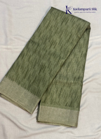 Kadamparii Silk olive green soft tussar silk saree with textured woven body and silver zari border, displayed on a white background.