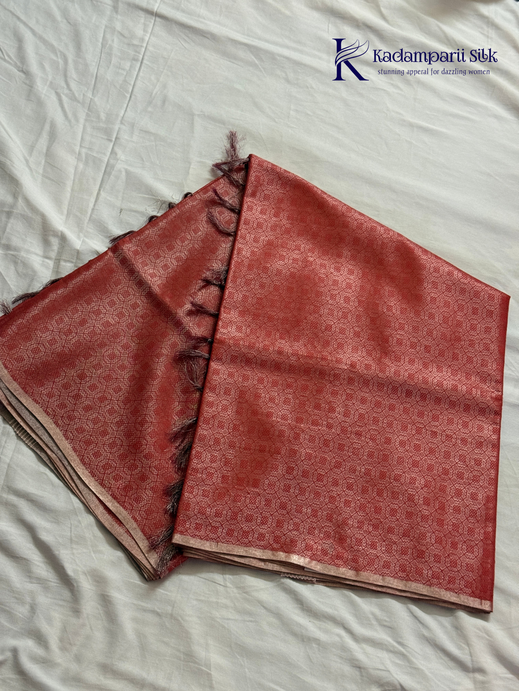 Rose pink semi Tussar jacquard saree with all-over woven geometric patterns, subtle silver zari detailing, soft textured finish, elegant tassels, and lightweight traditional drape by Kadamparii Silk.