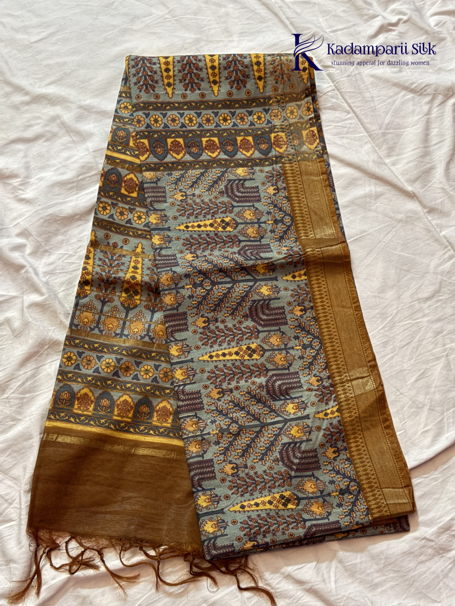 Kadamparii Silk grey semi tussar printed saree with traditional floral and heritage motifs, golden woven border, soft textured fabric, elegant tassels, and sophisticated ethnic design.