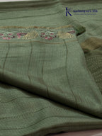 Sage green Tussar silk saree with embroidered peacock and floral border, subtle zari detailing, textured lightweight fabric, tassel finish, and elegant traditional styling by Kadamparii Silk.