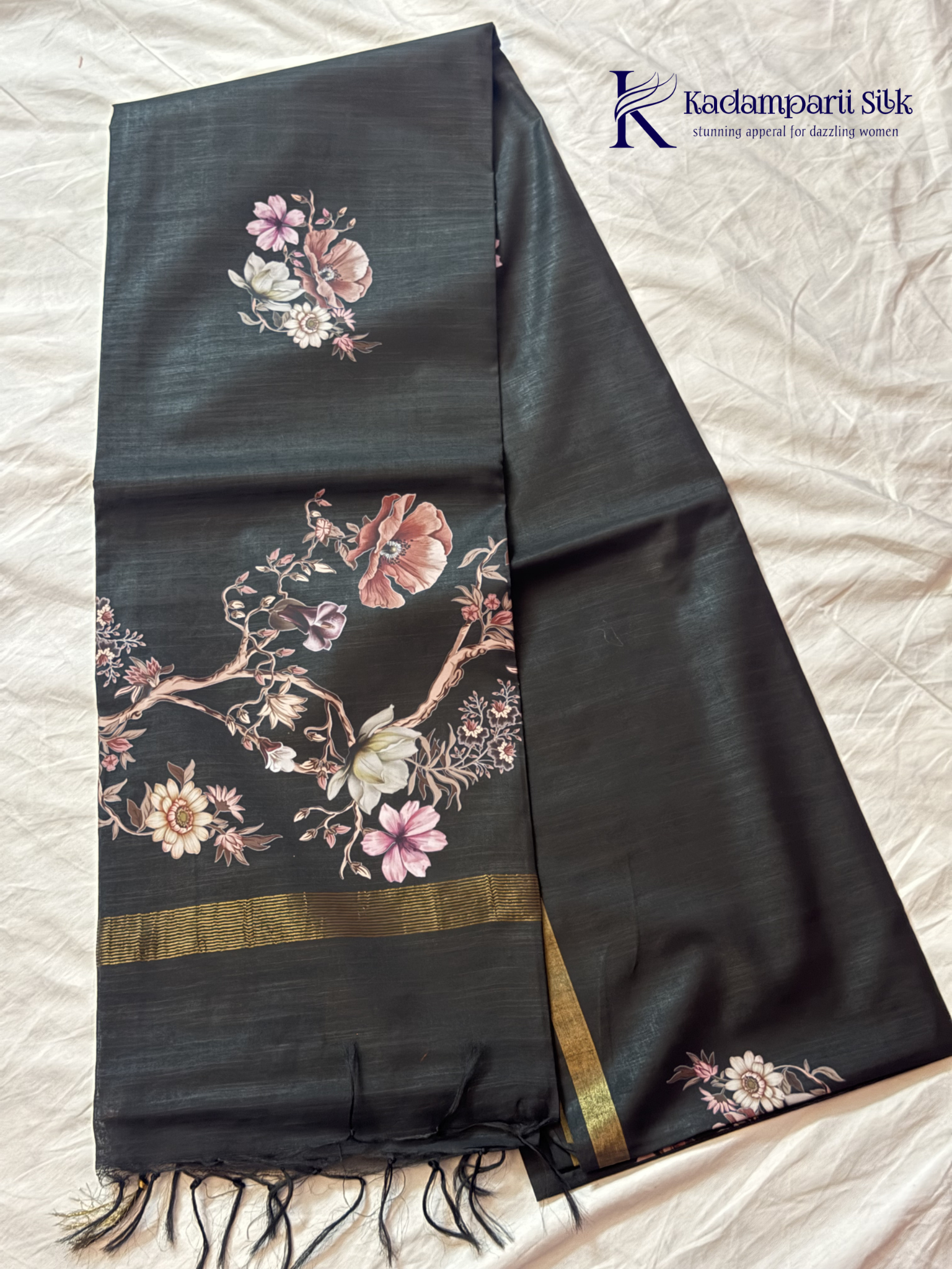 Black semi tussar saree with floral digital print and subtle golden zari border by Kadamparii Silk.