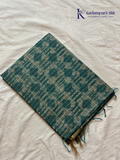 Kadamparii Silk teal semi tussar batik printed saree with abstract geometric patterns, subtle golden woven accents, soft textured fabric, tassel detailing, and elegant traditional design.