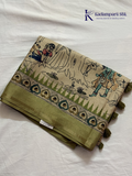 Soft Tussar saree with traditional pencil art print featuring mythological village scene motifs, subtle olive green zari border, artistic hand-drawn style detailing, and elegant lightweight drape by Kadamparii Silk.