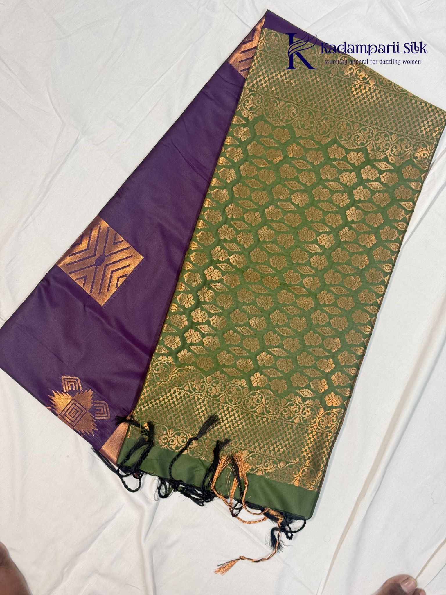 Kadamparii Silk royal purple semi soft silk saree with olive green zari woven pallu, intricate checkered motifs, copper gold zari border, geometric zari designs, and tassel detailing.