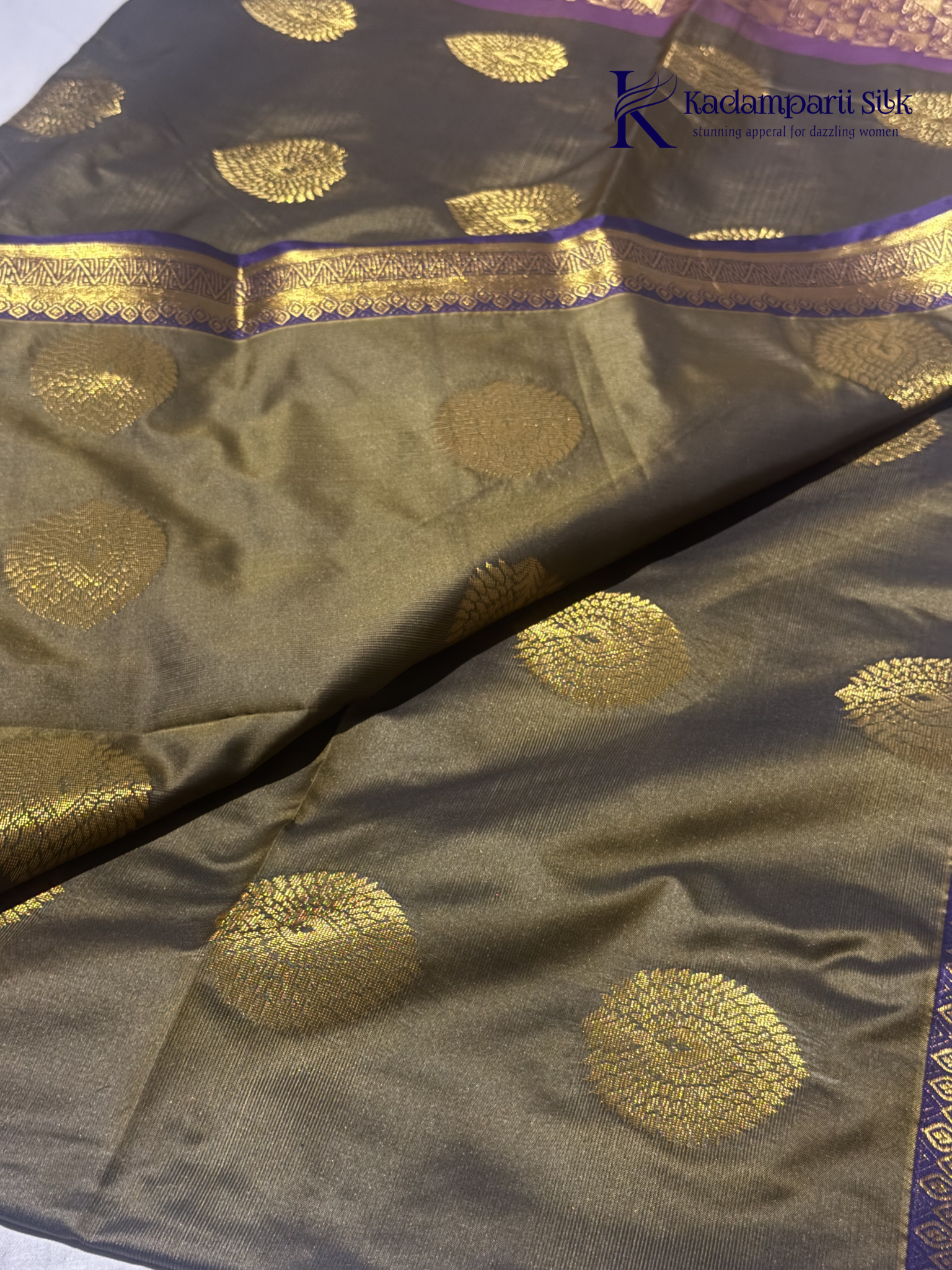 Kadamparii Silk olive green semi soft silk saree with gold zari peacock motifs, rich purple woven pallu, intricate zari border, and tassel detailing.