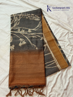 Grey Chenderi silk cotton saree with elegant floral vine design, intricate French knot work, copper-toned border and pallu, soft lightweight fabric, tassel detailing, and graceful ethnic styling by Kadamparii Silk.