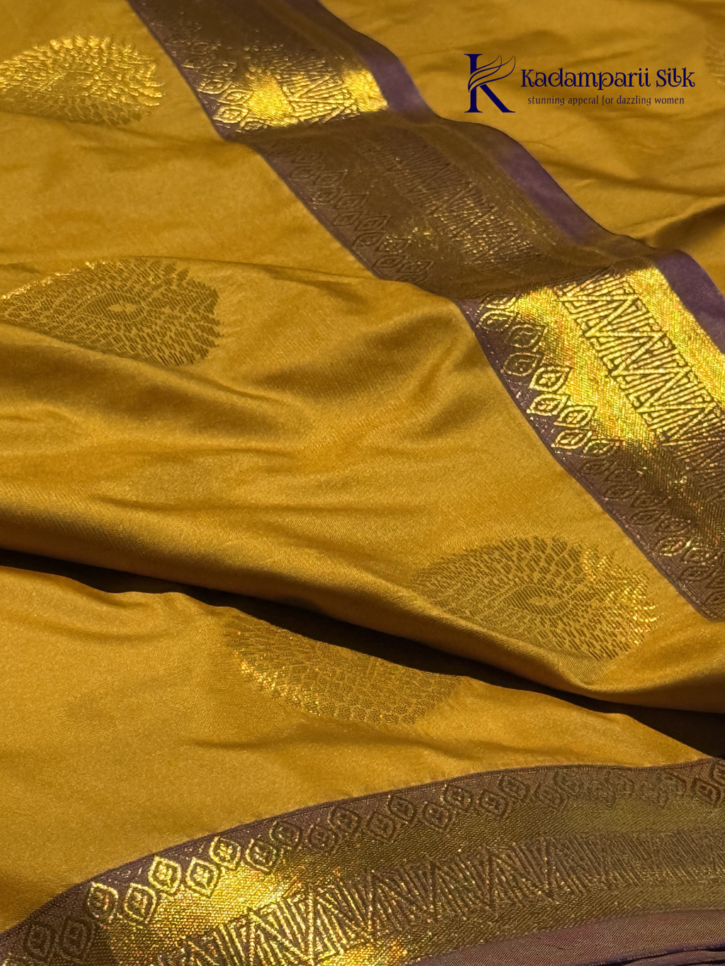 Kadamparii Silk mustard yellow semi soft silk saree with gold zari motifs, rich purple checkered zari pallu, ornate woven border, royal blue accents, and tassel detailing.