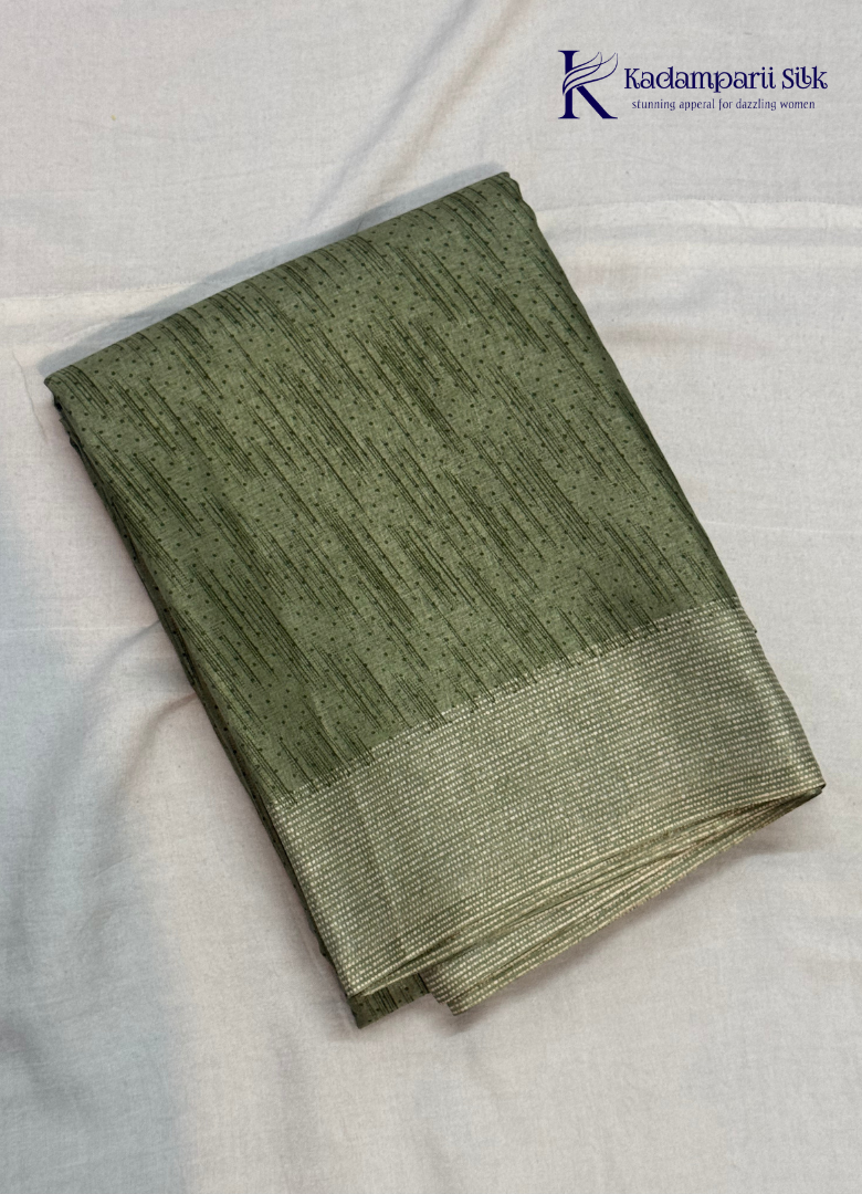 Kadamparii Silk olive green soft tussar silk saree with textured woven body and silver zari border, displayed on a white background.