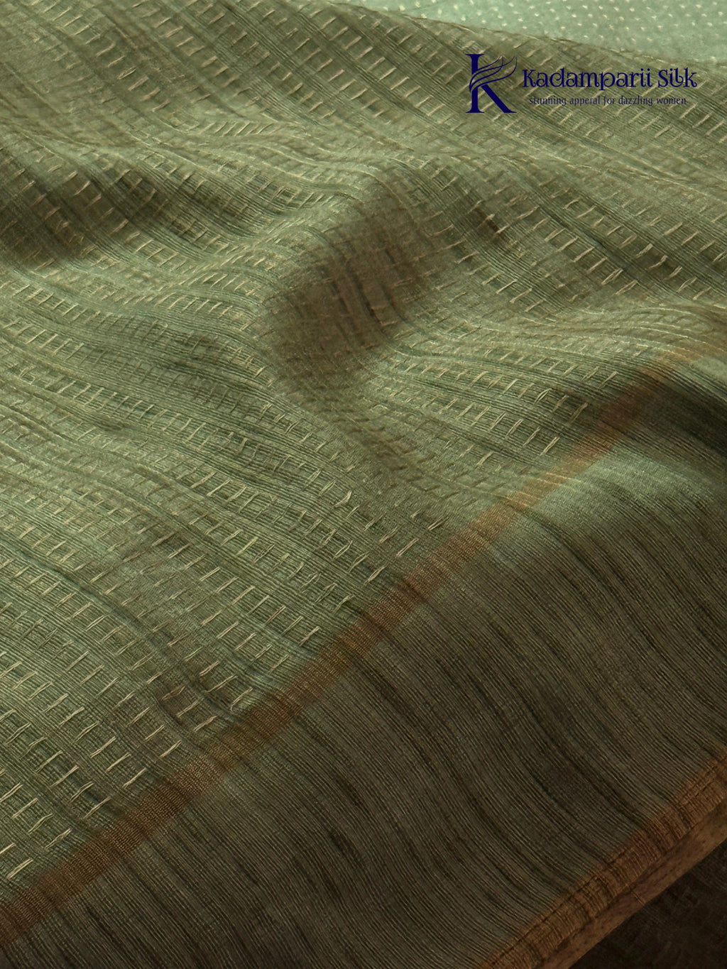 Sage green Tussar silk saree with embroidered peacock and floral border, subtle zari detailing, textured lightweight fabric, tassel finish, and elegant traditional styling by Kadamparii Silk.