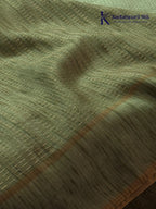 Sage green Tussar silk saree with embroidered peacock and floral border, subtle zari detailing, textured lightweight fabric, tassel finish, and elegant traditional styling by Kadamparii Silk.