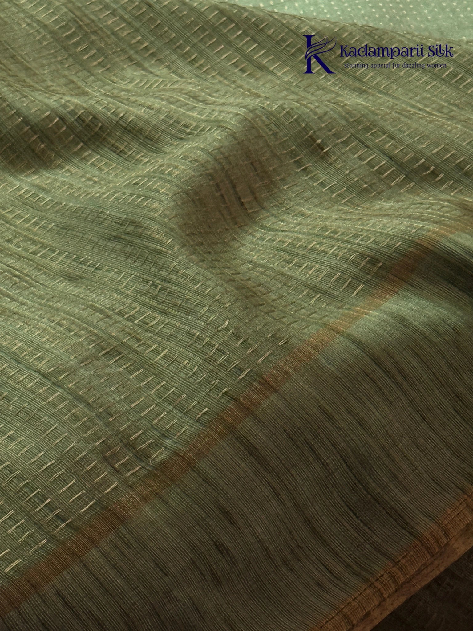 Sage green Tussar silk saree with embroidered peacock and floral border, subtle zari detailing, textured lightweight fabric, tassel finish, and elegant traditional styling by Kadamparii Silk.