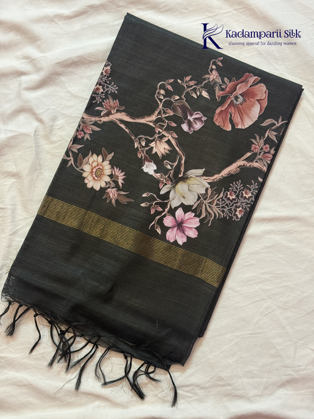Black semi tussar saree with floral digital print and subtle golden zari border by Kadamparii Silk.