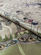 Soft Tussar saree with traditional pencil art print featuring mythological village scene motifs, subtle olive green zari border, artistic hand-drawn style detailing, and elegant lightweight drape by Kadamparii Silk.