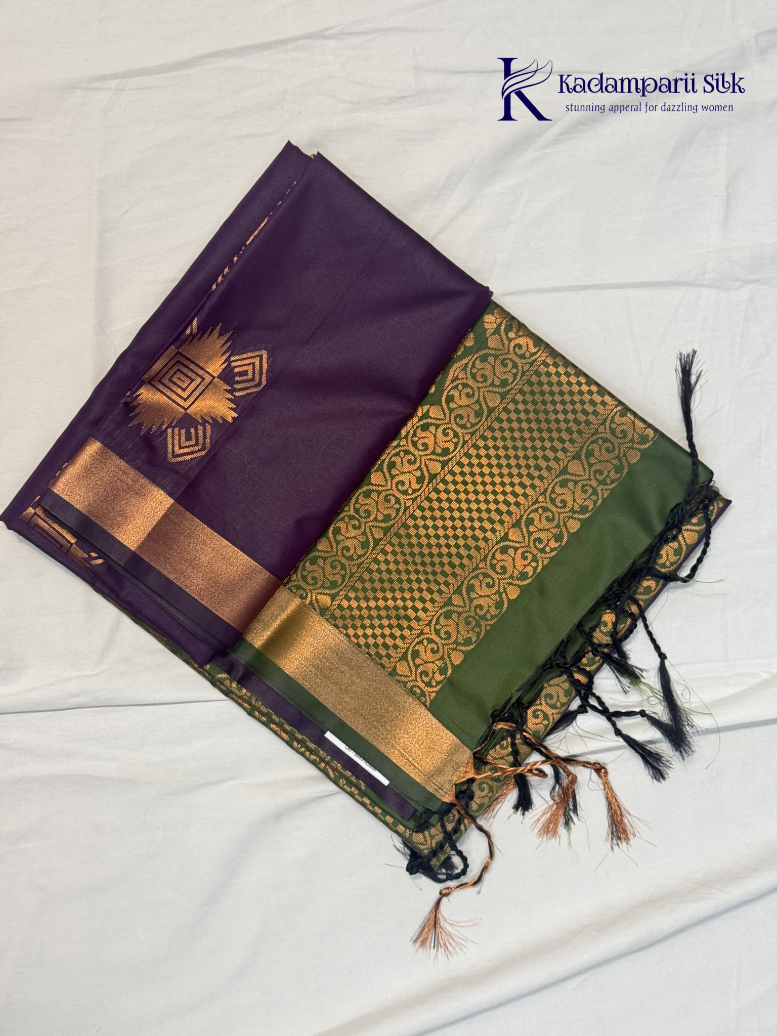 Kadamparii Silk royal purple semi soft silk saree with olive green zari woven pallu, intricate checkered motifs, copper gold zari border, geometric zari designs, and tassel detailing.