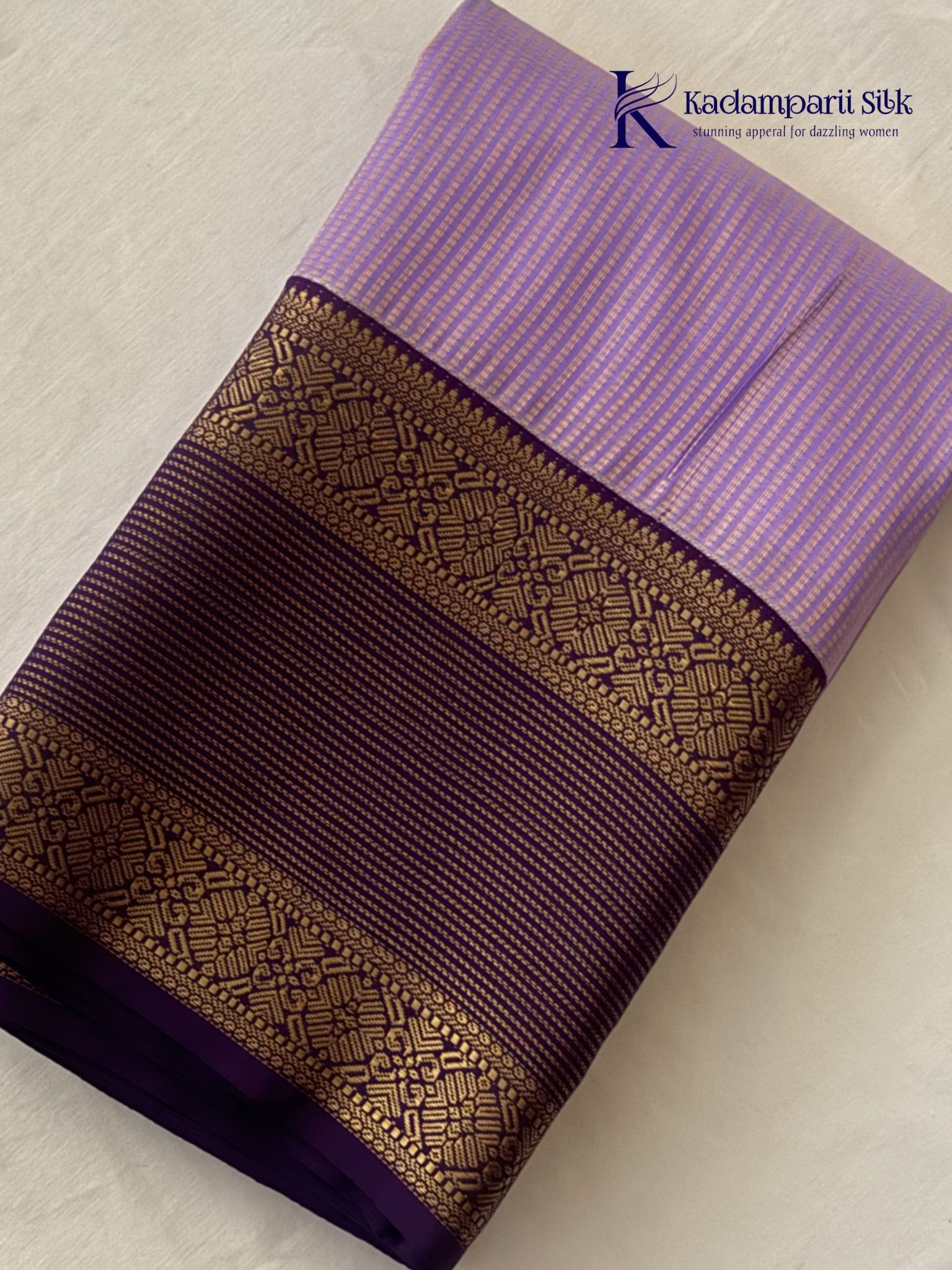 Lavender art silk saree with royal purple zari woven border and gold stripe detailing displayed on white background
