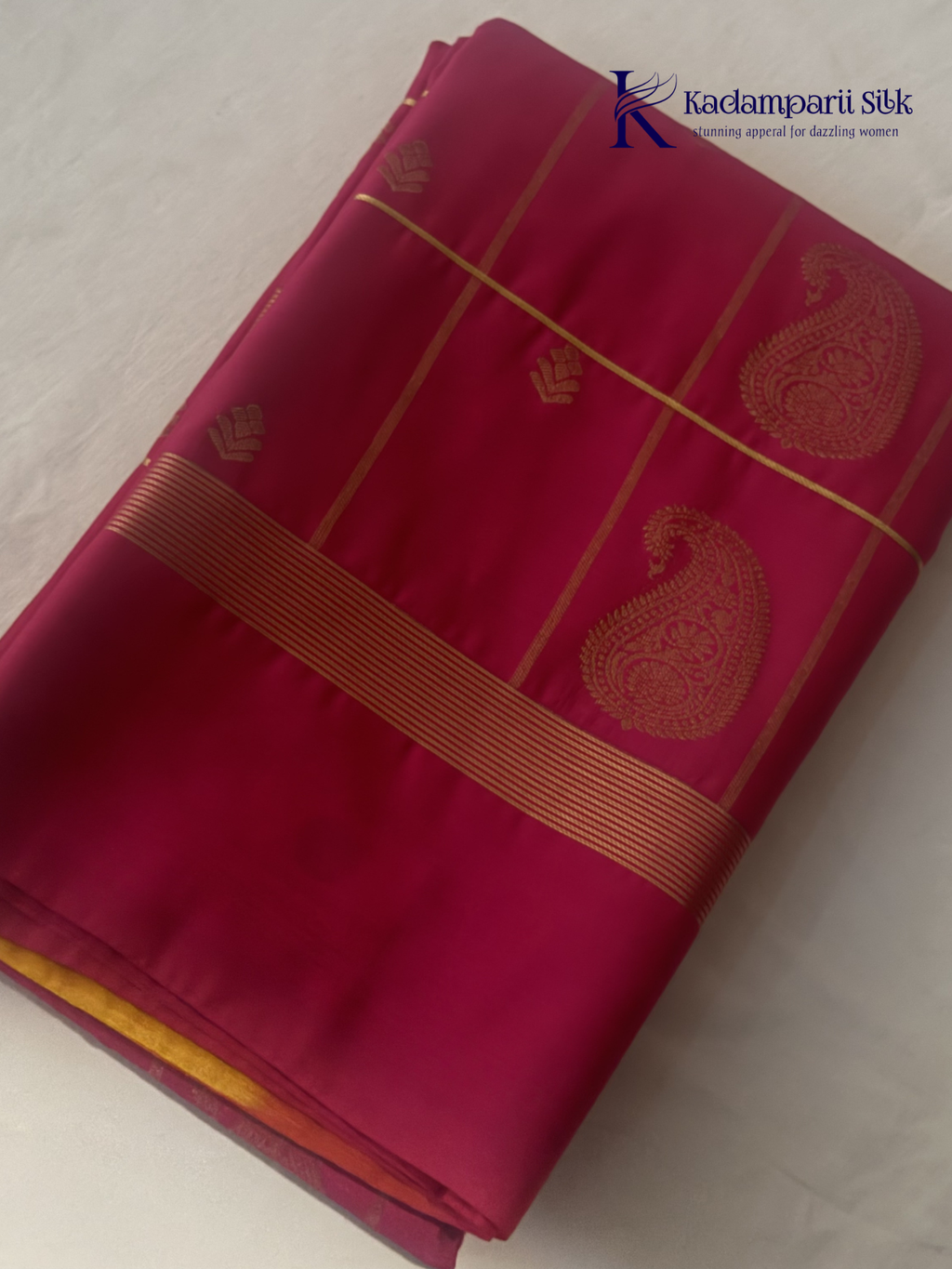Pink art silk saree with mustard zari border and traditional gold woven motifs displayed on white background